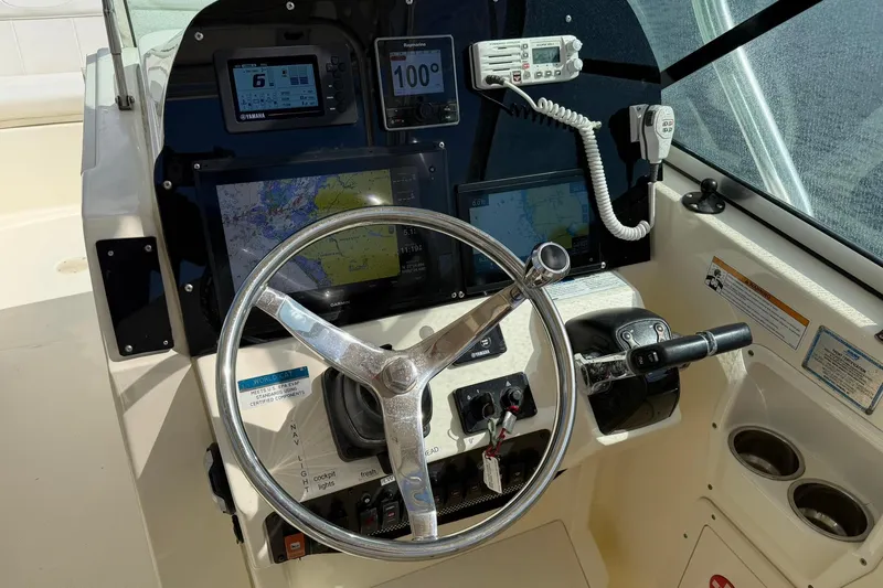 Slide: The Image of 2013 World Cat 290 DC boat dashboard with steering wheel and navigation instruments. - 15