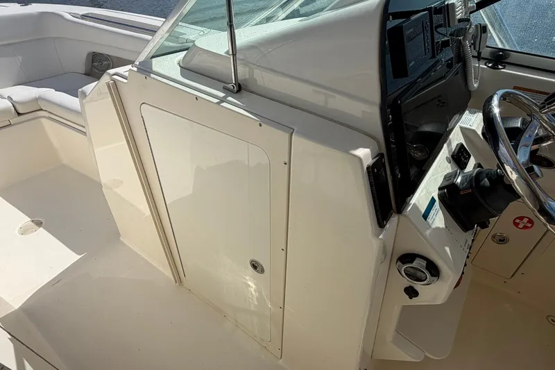 Slide: The Image of 2013 World Cat 290 DC boat interior with steering wheel and seating area. - 21