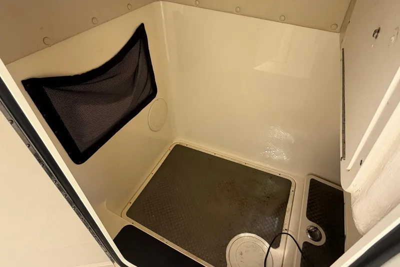 Slide: The Image of Interior cabin of 2013 World Cat 290 DC boat, featuring storage net and non-slip flooring. - 22