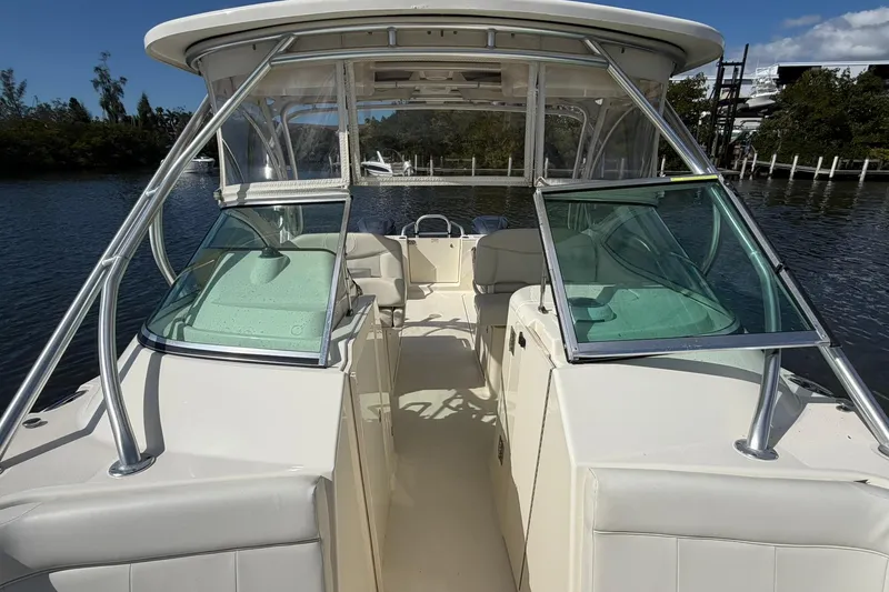 Slide: The Image of 2013 World Cat 290 DC boat interior with open windshield, docked on a sunny day. - 26