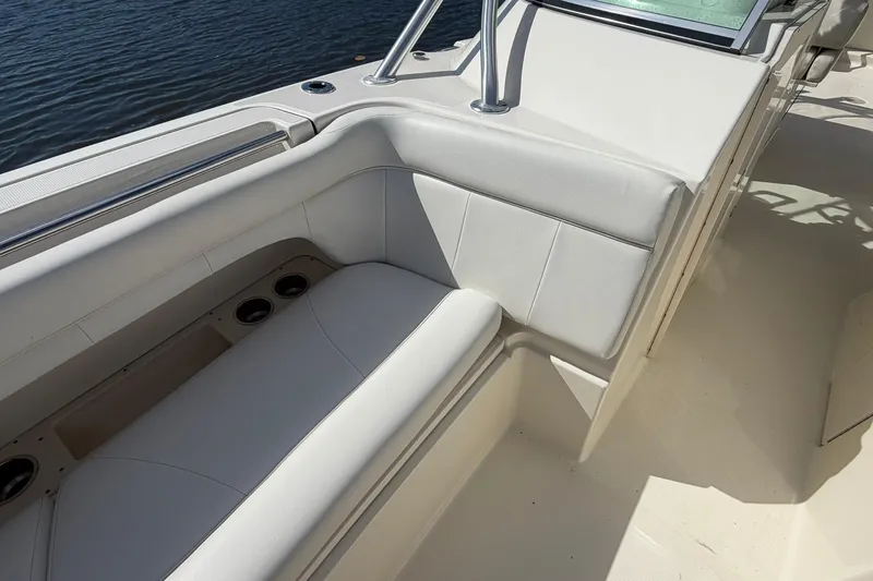 Slide: The Image of 2013 World Cat 290 DC boat interior with white cushioned seating and cup holders. - 27
