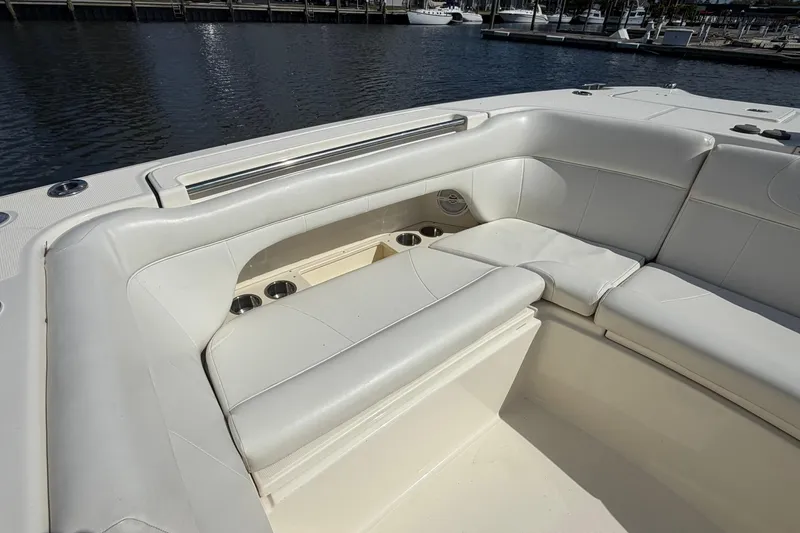 Slide: The Image of 2013 World Cat 290 DC boat with white cushioned seating and cup holders by the water. - 28