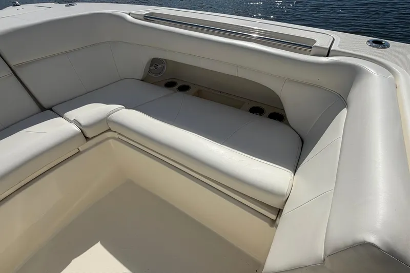 Slide: The Image of Luxurious seating on 2013 World Cat 290 DC boat, featuring white upholstery and cup holders. - 29