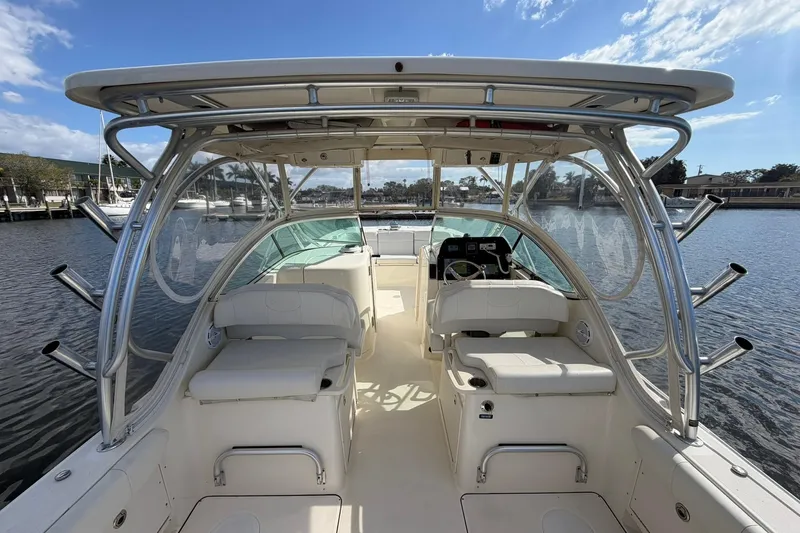 Slide: The Image of 2013 World Cat 290 DC boat interior with seating and helm, docked on a sunny day. - 30