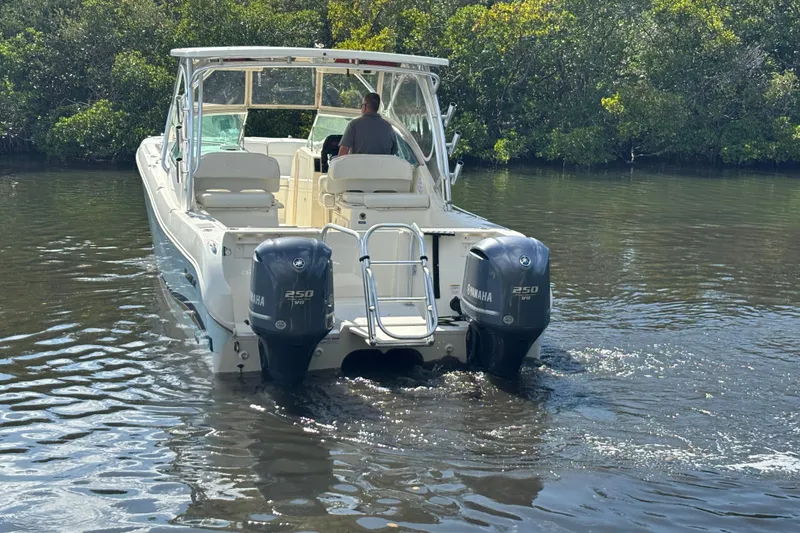 Slide: The Image of 2013 World Cat 290 DC boat with dual Yamaha engines navigating a calm waterway. - 7