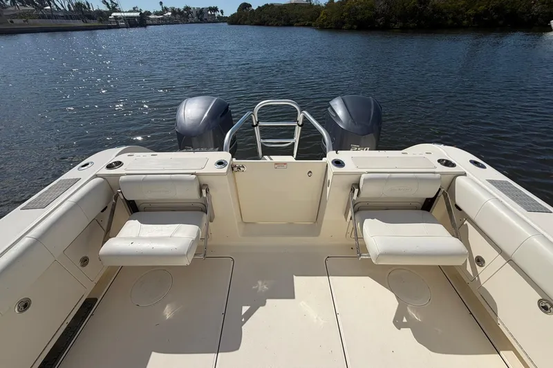 Slide: The Image of 2013 World Cat 290 DC boat with dual engines on a serene waterway. - 8