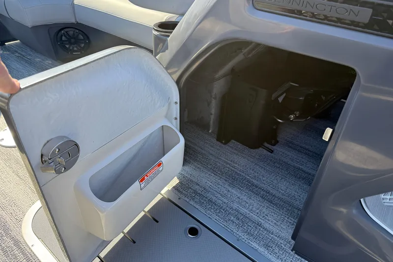 Slide: The Image of 2026 Bennington 24 M Sport Lounge Quad Bench interior storage compartment with open door. - 18