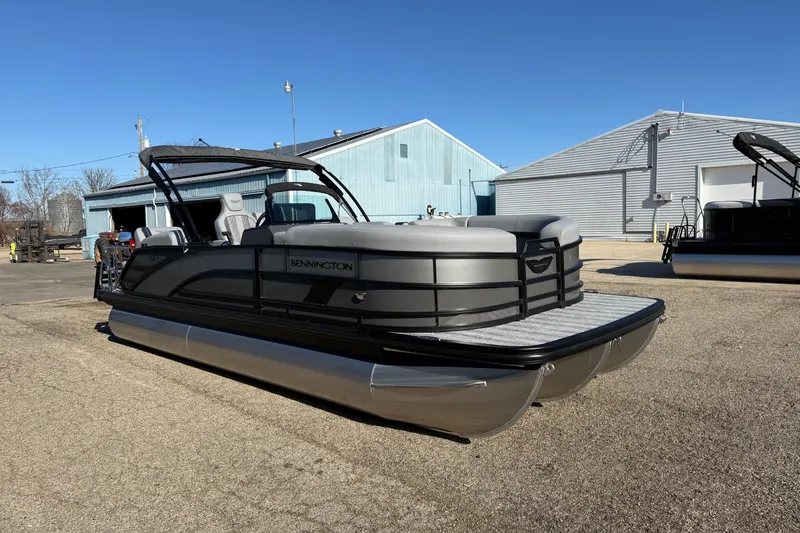 Slide: The Image of 2026 Bennington 24 M Sport Lounge Quad Bench pontoon boat in a marina setting. - 3