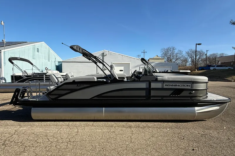 Slide: The Image of 2026 Bennington 24 M Sport Lounge Quad Bench pontoon boat in a parking lot. - 4