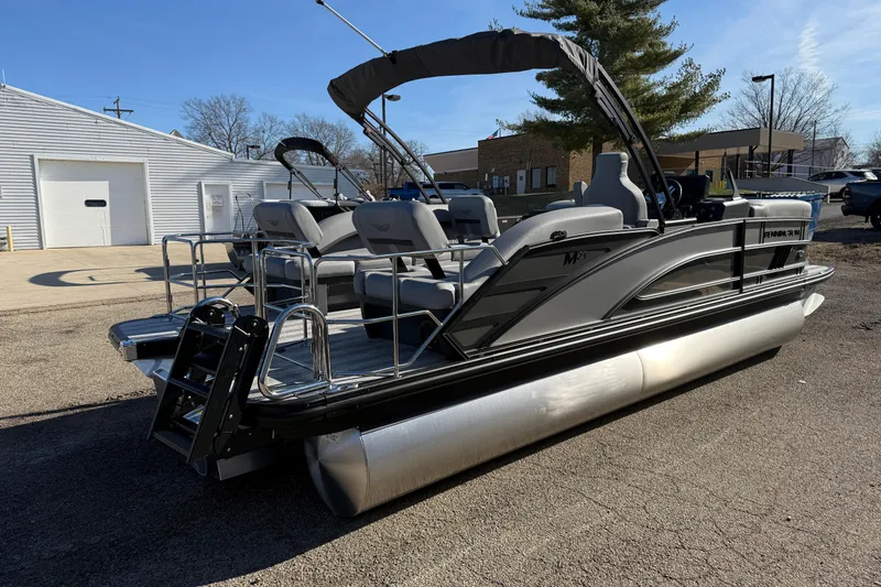 Slide: The Image of 2026 Bennington 24 M Sport Lounge Quad Bench pontoon boat in a parking lot. - 5
