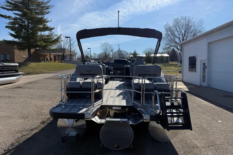 Slide: The Image of 2026 Bennington 24 M Sport Lounge Quad Bench pontoon boat in a sunny outdoor setting. - 6