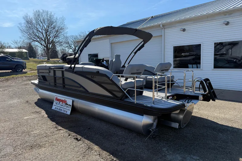 Slide: The Image of 2026 Bennington 24 M Sport Lounge Quad Bench pontoon boat parked outdoors. - 7