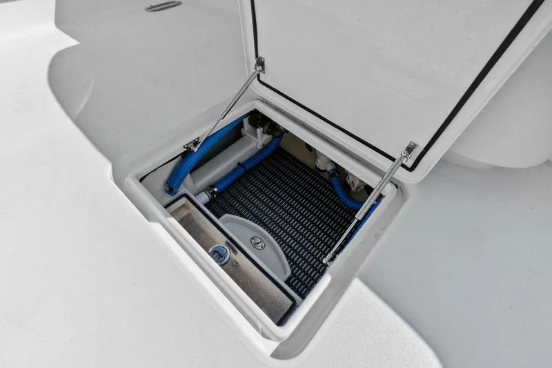 Slide: The Image of 2024 Custom Center Console High Ground Boatworks storage compartment with blue hoses and hydraulic lift. - 14