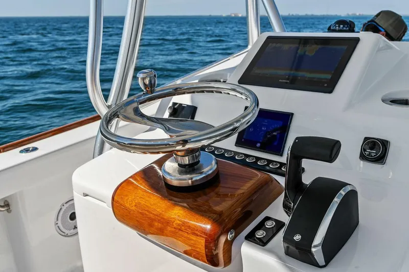 Slide: The Image of 2024 Custom Center Console High Ground Boatworks helm with modern controls and ocean view. - 19