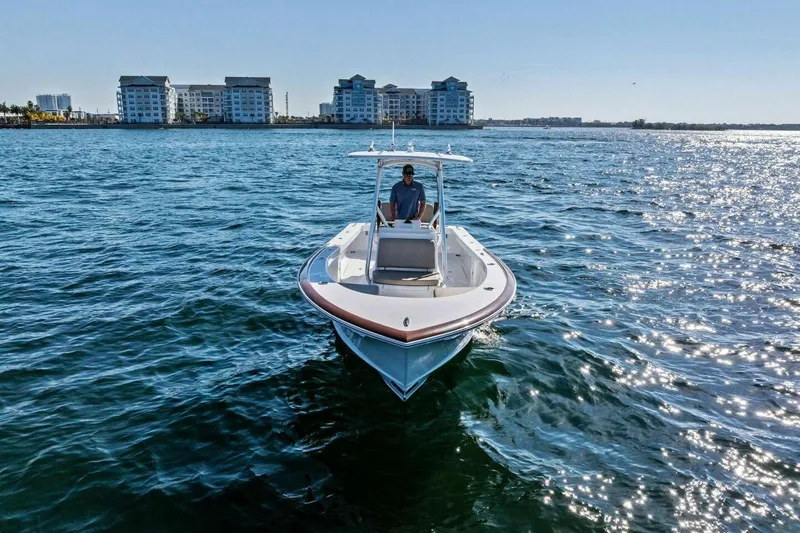 Slide: The Image of 2024 Custom Center Console High Ground Boatworks on sparkling water near coastal buildings. - 49