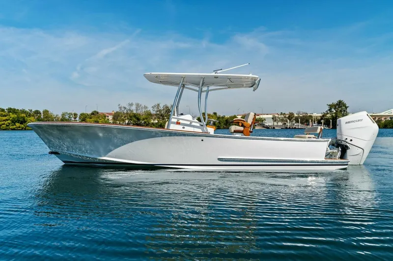 Slide: The Image of 2024 Custom Center Console High Ground Boatworks on calm water, featuring sleek design and Mercury engine. - 54