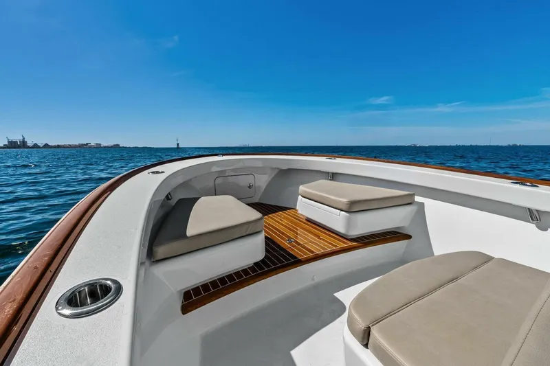 Slide: The Image of 2024 Custom Center Console High Ground Boatworks on open water, featuring cushioned seating. - 6