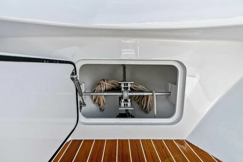 Slide: The Image of 2024 Custom Center Console High Ground Boatworks anchor storage with rope on teak deck. - 8