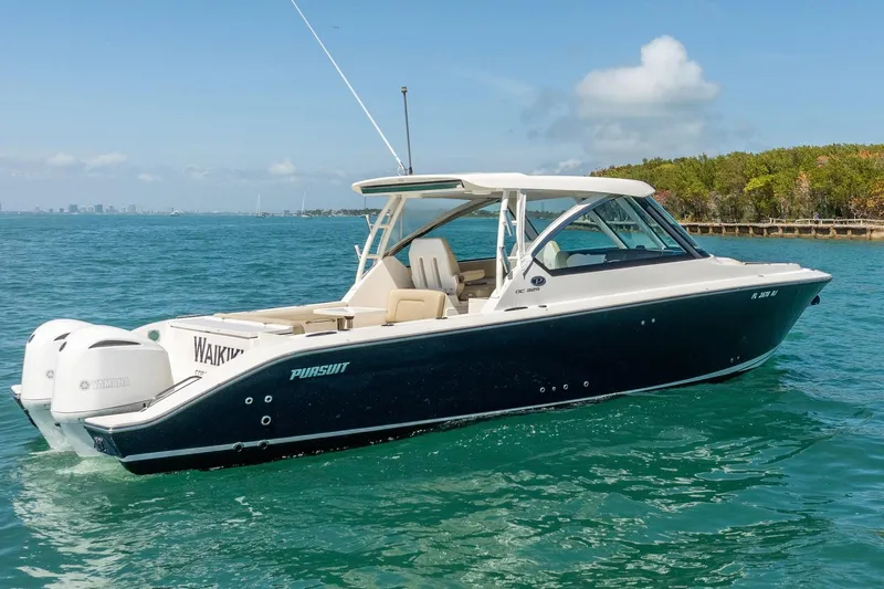 The Image of 2017 Pursuit DC 325 Dual Console boat cruising on clear blue water. - 1