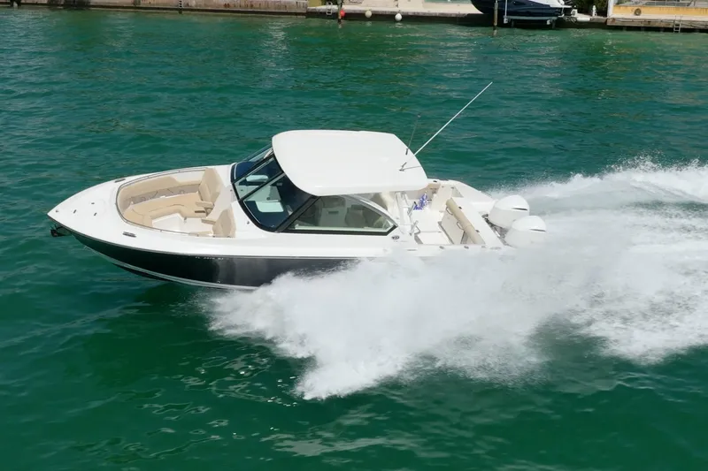 Slide: The Image of 2017 Pursuit DC 325 Dual Console boat speeding on water, showcasing sleek design and powerful performance. - 16