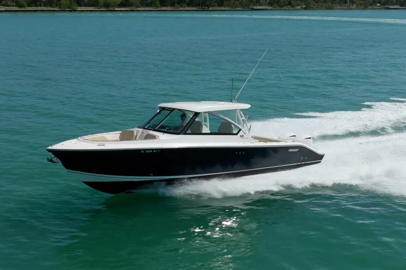 Slide: The Image of 2017 Pursuit DC 325 Dual Console boat cruising on clear blue water. - 19