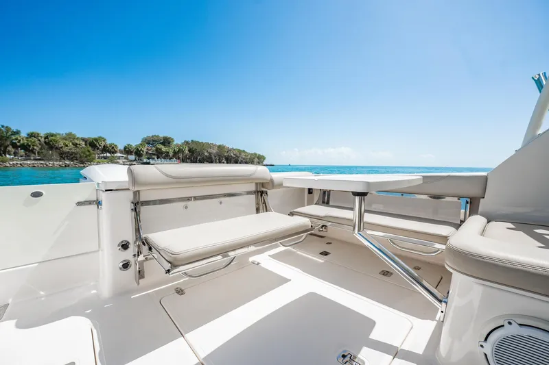 Slide: The Image of 2017 Pursuit DC 325 Dual Console boat interior with seating and table, ocean view. - 21