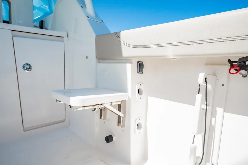 Slide: The Image of 2017 Pursuit DC 325 Dual Console boat interior with foldable seat and storage compartment. - 22