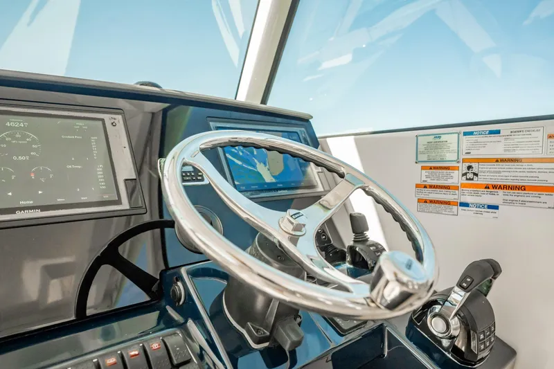 Slide: The Image of 2017 Pursuit DC 325 Dual Console helm with steering wheel and navigation displays. - 26