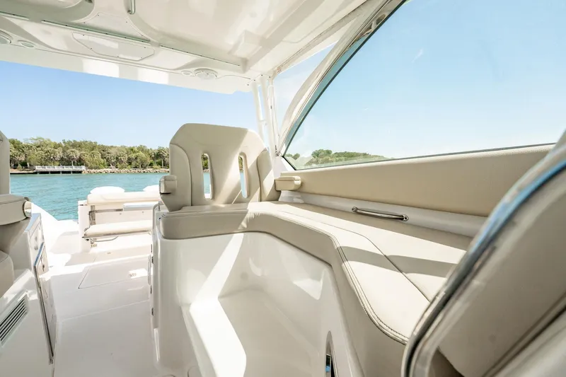 Slide: The Image of 2017 Pursuit DC 325 Dual Console interior with beige seating and ocean view. - 29