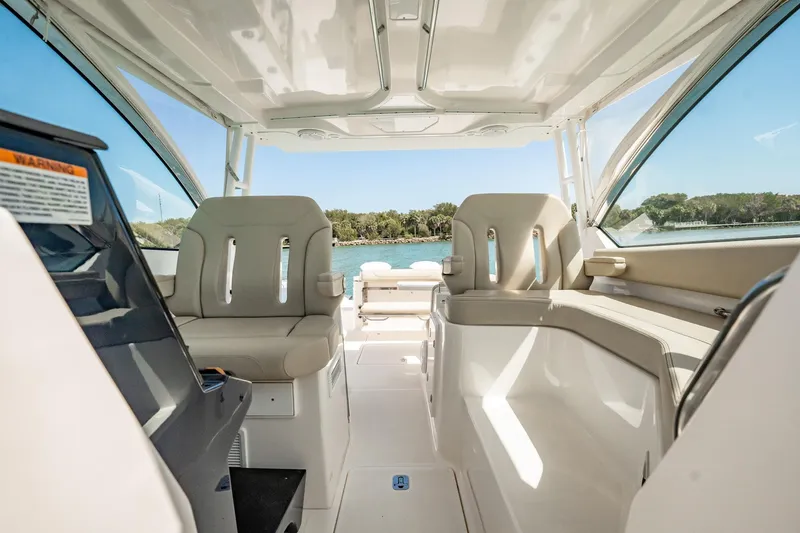 Slide: The Image of 2017 Pursuit DC 325 Dual Console boat interior with seating and water view. - 30