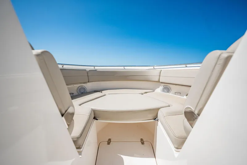 Slide: The Image of 2017 Pursuit DC 325 Dual Console boat interior with beige seating under clear blue sky. - 34