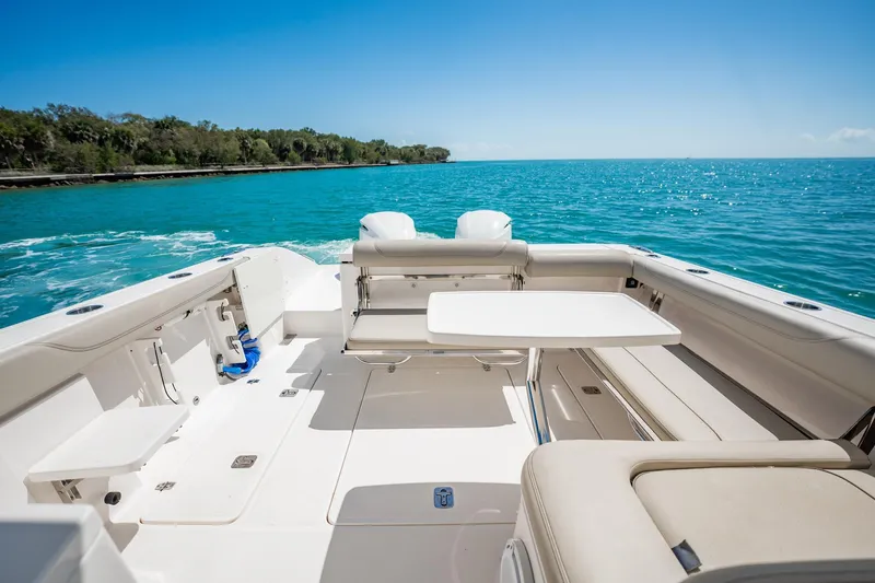 Slide: The Image of 2017 Pursuit DC 325 Dual Console boat interior with seating and table, cruising on blue water. - 37