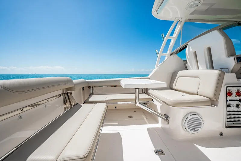 Slide: The Image of 2017 Pursuit DC 325 Dual Console boat interior with seating and table, ocean view. - 38
