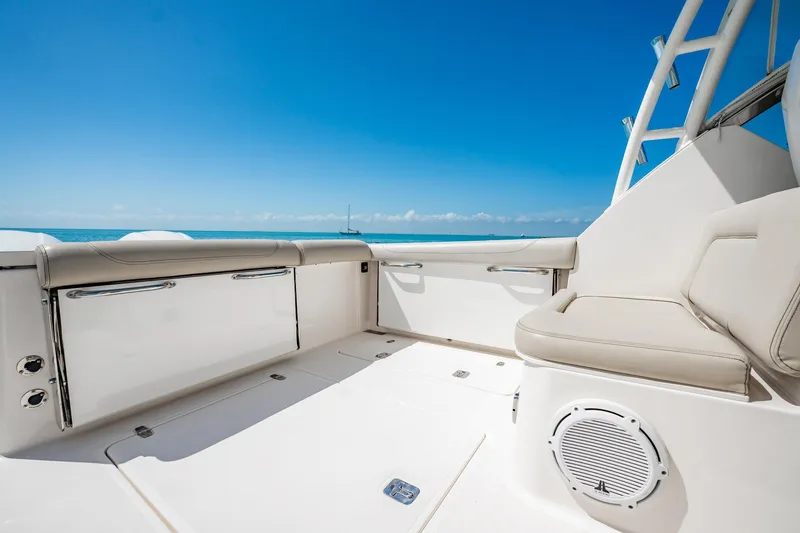 Slide: The Image of 2017 Pursuit DC 325 Dual Console boat interior with ocean view, featuring cushioned seating. - 41