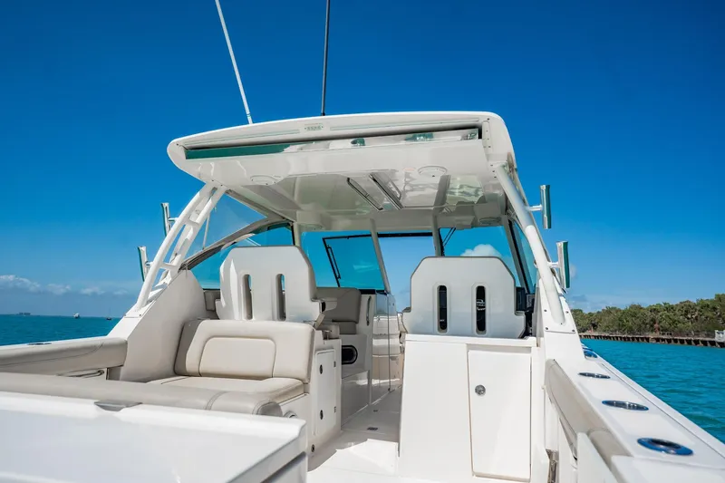 Slide: The Image of 2017 Pursuit DC 325 Dual Console boat interior with seating, under clear blue sky. - 44