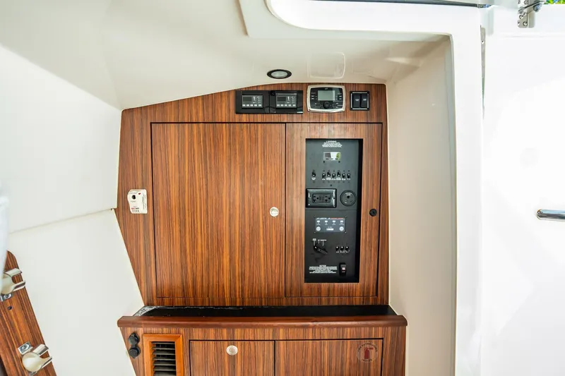 Slide: The Image of 2017 Pursuit DC 325 Dual Console interior control panel with wood finish. - 48