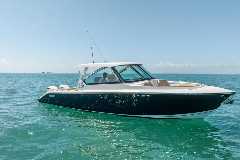 Slide: The Image of 2017 Pursuit DC 325 Dual Console boat cruising on clear blue water. - 57