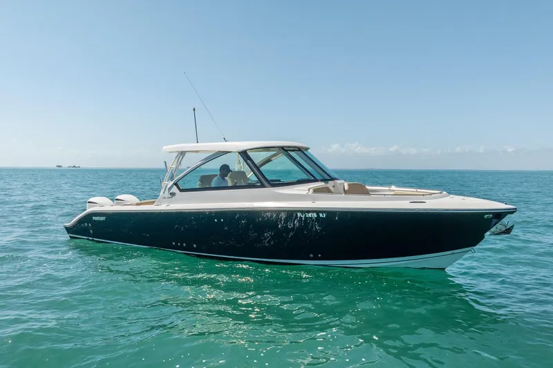 Slide: The Image of 2017 Pursuit DC 325 Dual Console boat on clear blue water. - 58