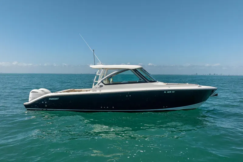 Slide: The Image of 2017 Pursuit DC 325 Dual Console boat on calm ocean waters under clear blue sky. - 60