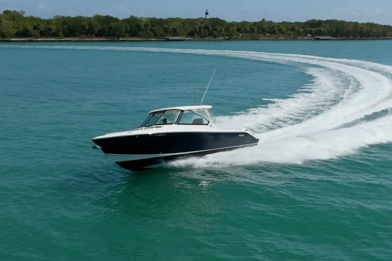 Slide: The Image of 2017 Pursuit DC 325 Dual Console cruising on clear blue water. - 65