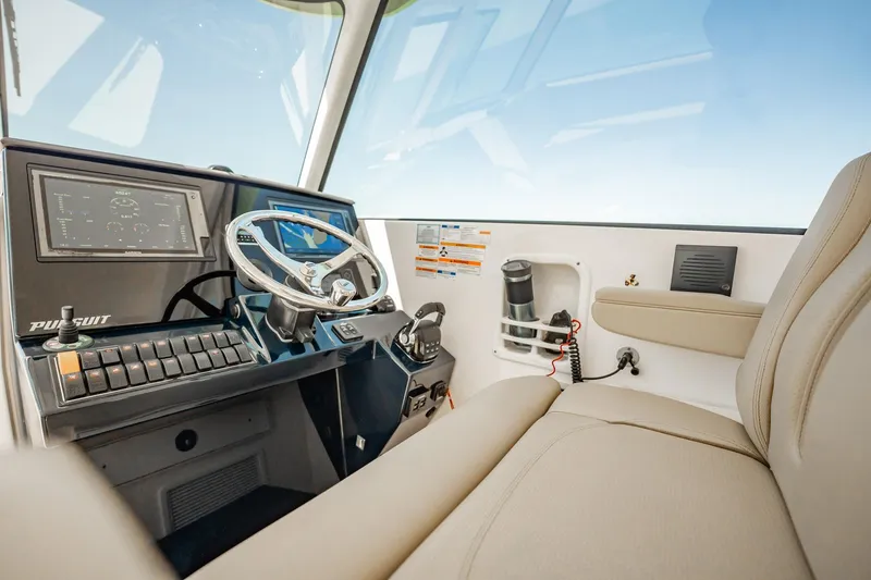 Slide: The Image of 2017 Pursuit DC 325 Dual Console boat interior with steering wheel and dashboard controls. - 70