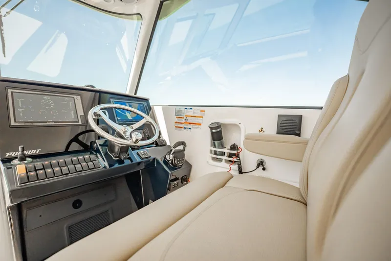 Slide: The Image of 2017 Pursuit DC 325 Dual Console boat interior with steering wheel and dashboard controls. - 71
