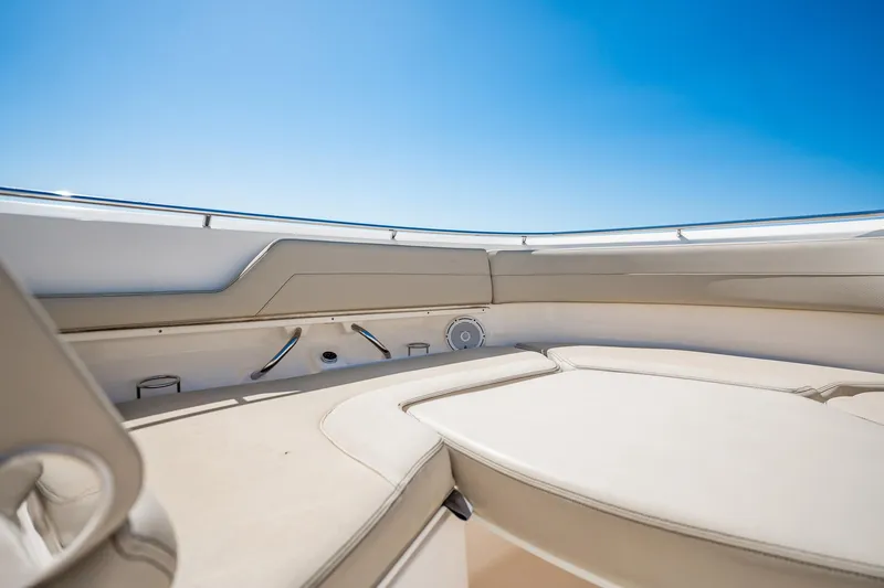 Slide: The Image of 2017 Pursuit DC 325 Dual Console boat interior with beige seating under clear blue sky. - 74