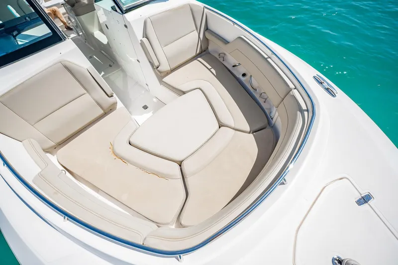 Slide: The Image of 2017 Pursuit DC 325 Dual Console boat interior with beige seating, on clear blue water. - 75