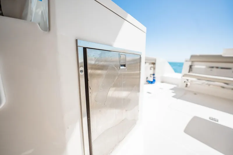 Slide: The Image of 2017 Pursuit DC 325 Dual Console boat interior with stainless steel storage compartment. - 85