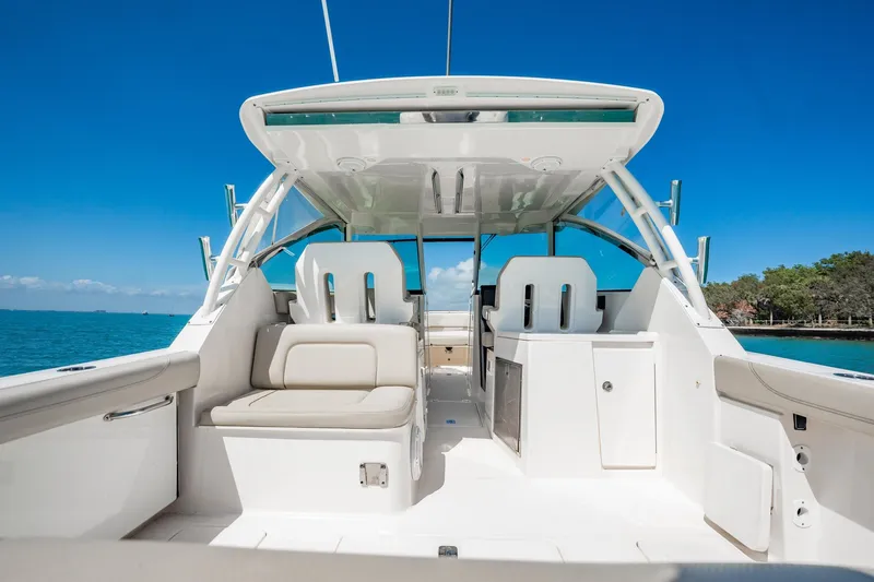 Slide: The Image of 2017 Pursuit DC 325 Dual Console boat interior with seating, ocean view, and clear blue sky. - 88