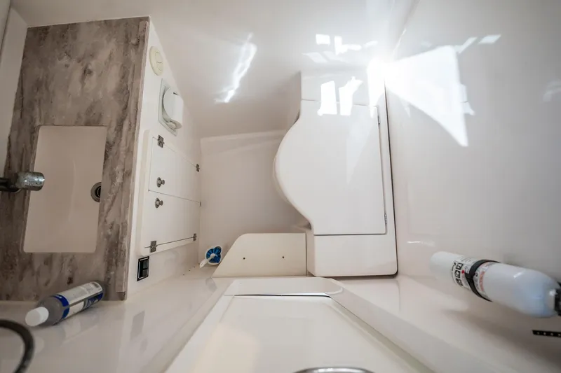 Slide: The Image of 2017 Pursuit DC 325 Dual Console boat interior with compact bathroom amenities. - 90