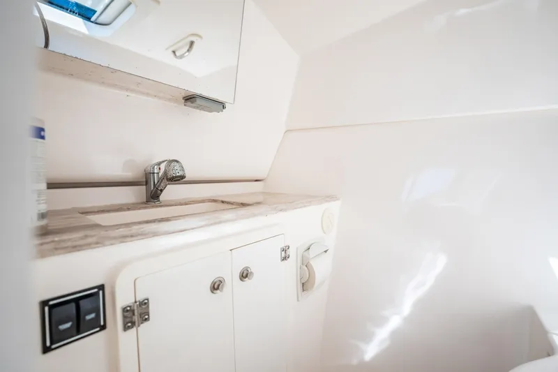 Slide: The Image of 2017 Pursuit DC 325 Dual Console boat interior with sink and storage cabinet. - 91