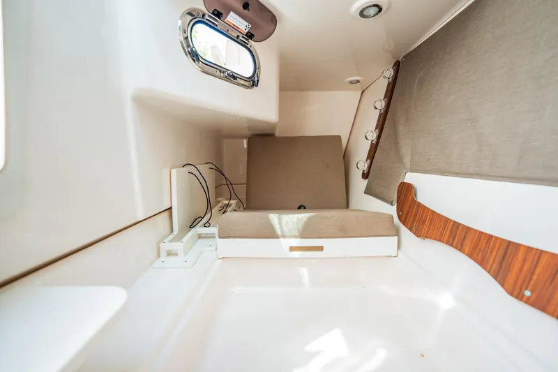 Slide: The Image of 2017 Pursuit DC 325 Dual Console cabin interior with seating and porthole window. - 92