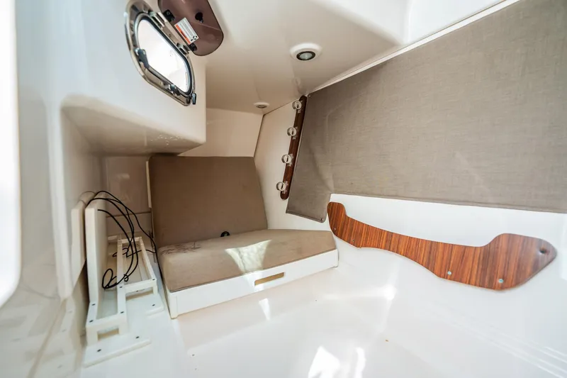 Slide: The Image of 2017 Pursuit DC 325 Dual Console cabin interior with seating and porthole. - 93